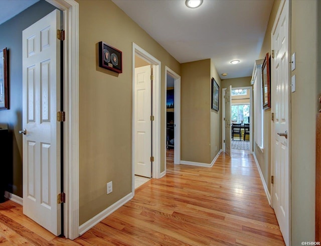 corridor with light wood-style floors and baseboards