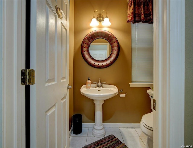 bathroom featuring tile patterned flooring, baseboards, and toilet