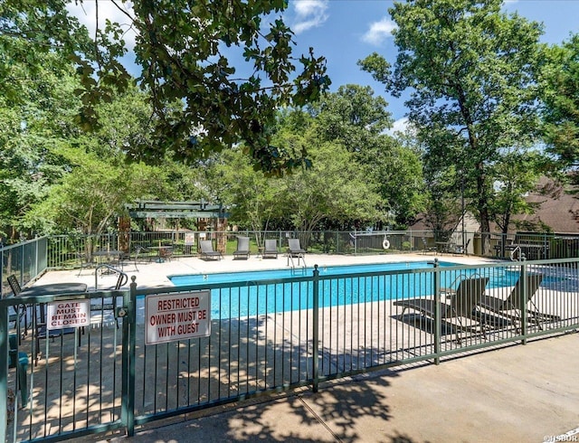 community pool featuring fence and a patio