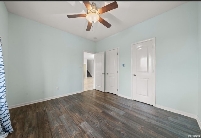 unfurnished bedroom with baseboards, wood finished floors, and a ceiling fan