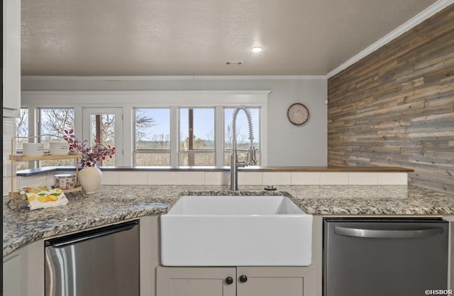 kitchen with stainless steel dishwasher, crown molding, and a sink