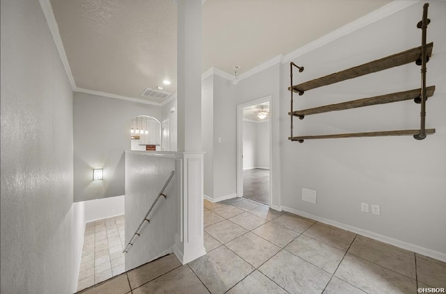 staircase featuring tile patterned flooring, crown molding, visible vents, and baseboards