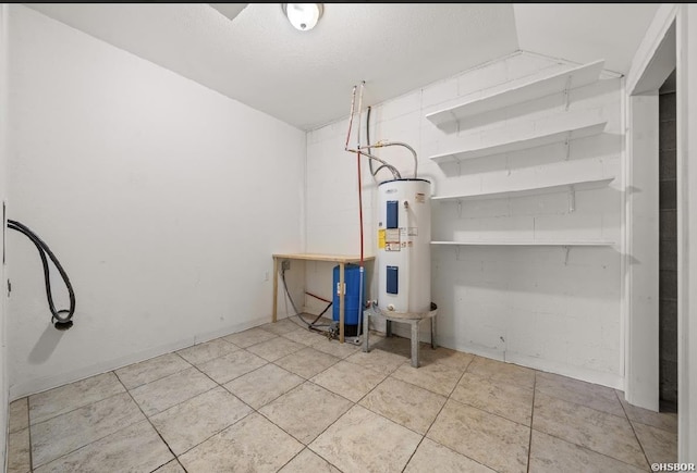 washroom featuring light tile patterned floors, water heater, and a textured ceiling