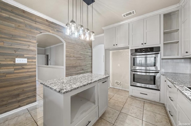 kitchen with visible vents, double oven, ornamental molding, arched walkways, and open shelves