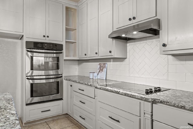 kitchen featuring decorative backsplash, double oven, black electric stovetop, and under cabinet range hood