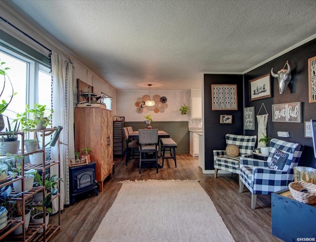 dining space with a textured ceiling, dark wood-type flooring, a wood stove, and a notable chandelier