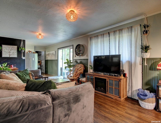 living area featuring ornamental molding, a textured ceiling, and wood finished floors