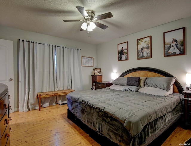 bedroom with light wood finished floors, a ceiling fan, and a textured ceiling