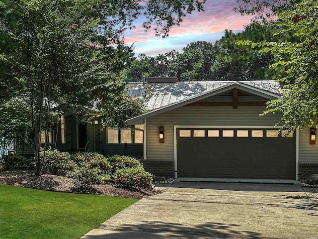 view of front facade with an attached garage, concrete driveway, and brick siding