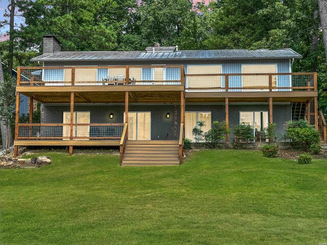 back of house featuring stairs, a chimney, a lawn, and brick siding