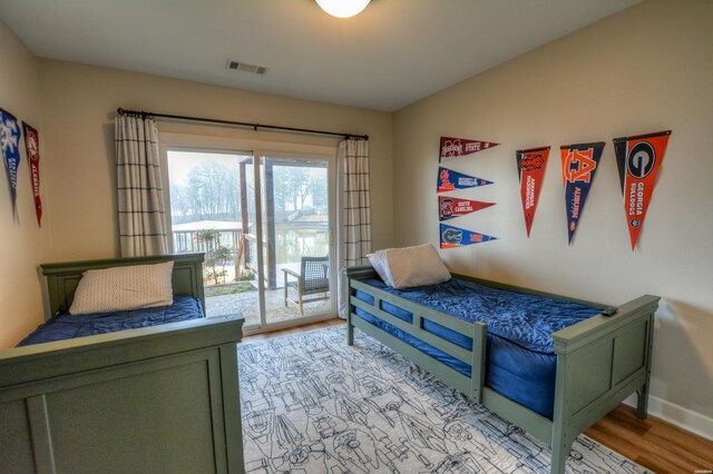 bedroom with access to exterior, baseboards, visible vents, and light wood finished floors