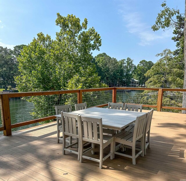 deck featuring outdoor dining space and a water view