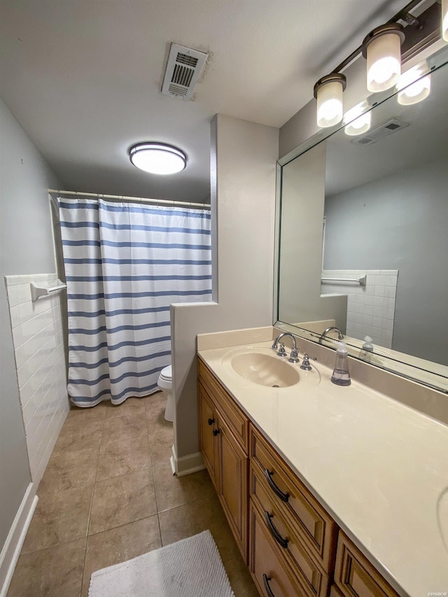 bathroom with tile patterned flooring, visible vents, vanity, and toilet