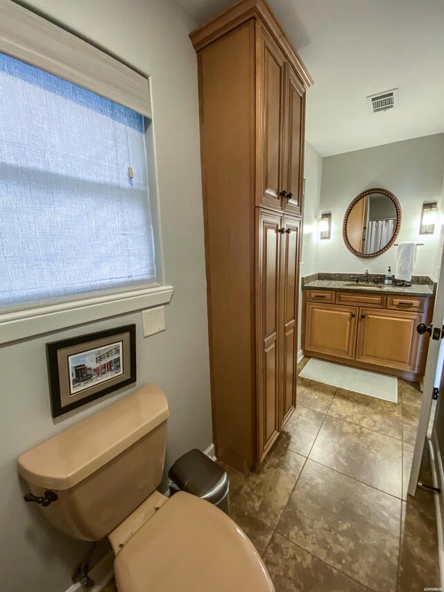 bathroom with toilet, visible vents, and vanity