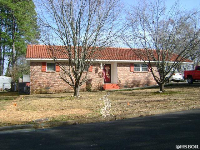 ranch-style home with crawl space, a tile roof, a front lawn, and brick siding