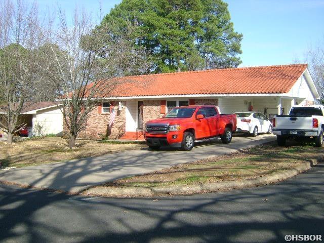 ranch-style home with a tiled roof and concrete driveway