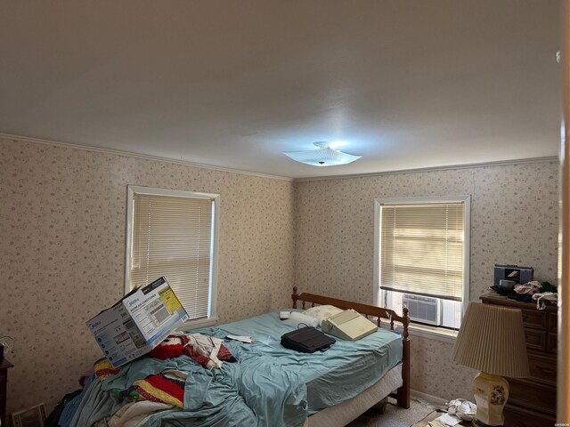 bedroom with crown molding, cooling unit, and wallpapered walls