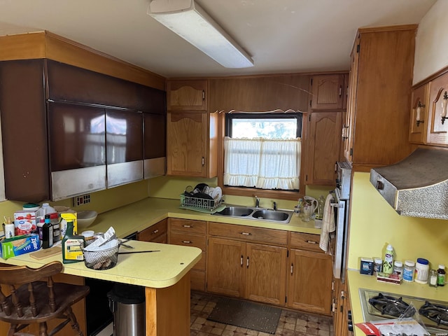 kitchen with stainless steel appliances, light countertops, a sink, and a breakfast bar area