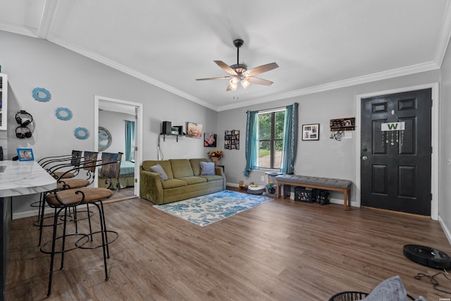 living room with lofted ceiling, ornamental molding, ceiling fan, wood finished floors, and baseboards