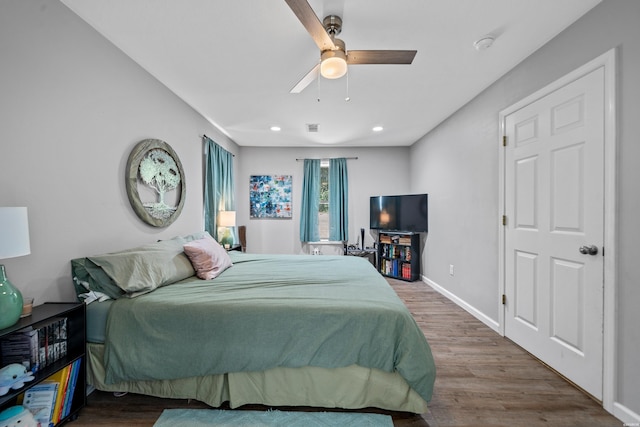 bedroom featuring baseboards, visible vents, wood finished floors, and recessed lighting