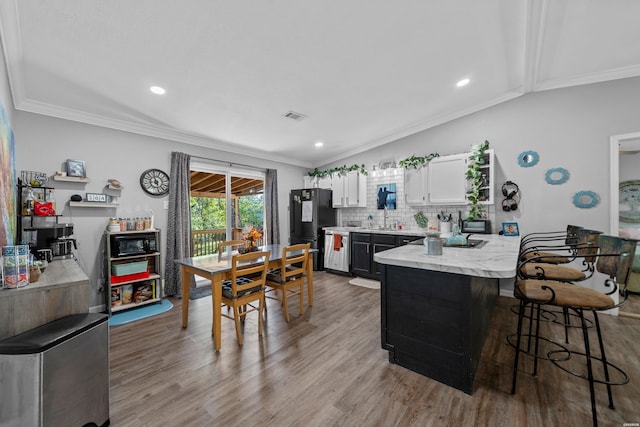 kitchen featuring light wood-style floors, visible vents, white cabinetry, and a kitchen breakfast bar