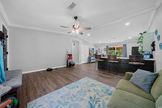 living area with visible vents, crown molding, baseboards, and wood finished floors