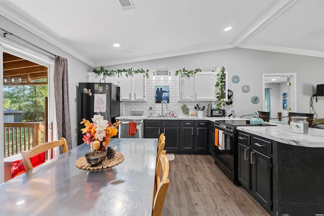 kitchen with appliances with stainless steel finishes, a sink, dark cabinetry, and white cabinets