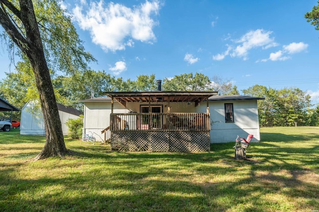 back of property with a deck and a yard