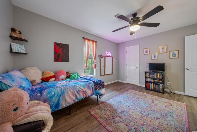 bedroom featuring a ceiling fan, baseboards, and wood finished floors