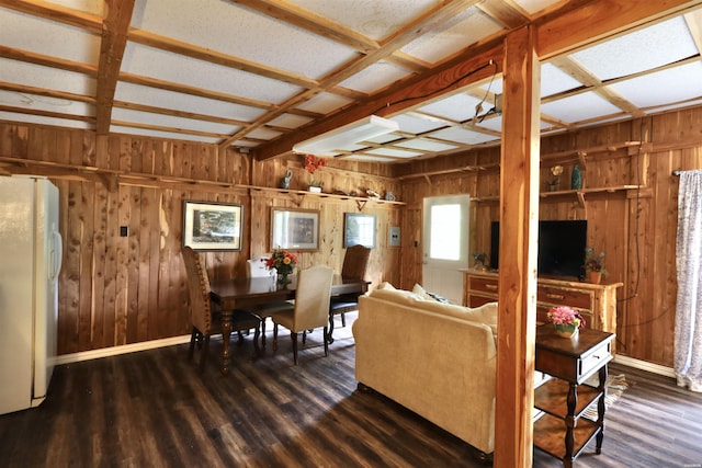 living area featuring wooden walls, coffered ceiling, baseboards, and wood finished floors