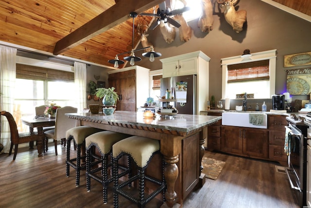 kitchen with range with electric stovetop, a center island, freestanding refrigerator, a breakfast bar area, and wood ceiling