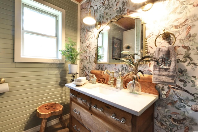 bathroom with a healthy amount of sunlight, vanity, and wallpapered walls