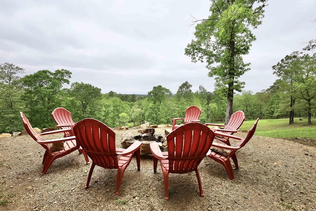 view of patio / terrace featuring a fire pit and a view of trees