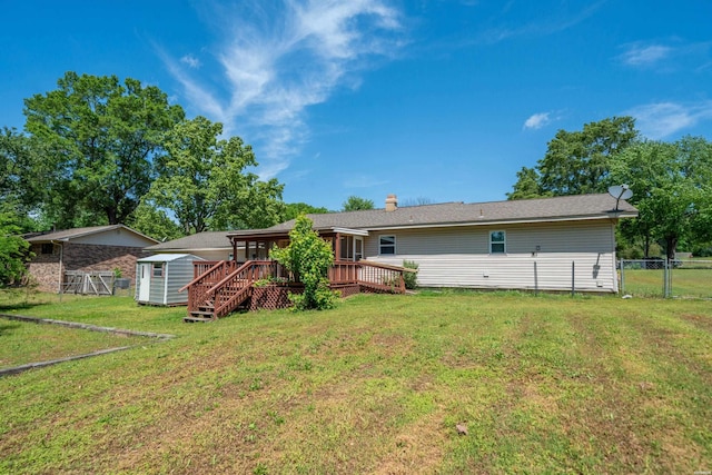 rear view of house with an outdoor structure, a wooden deck, fence, a storage unit, and a yard