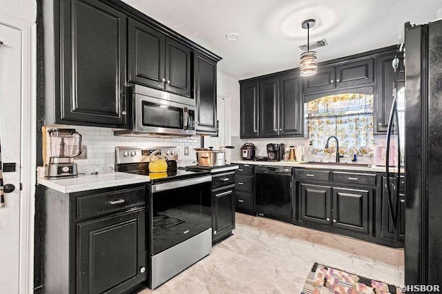 kitchen with a sink, dark cabinetry, backsplash, and black appliances