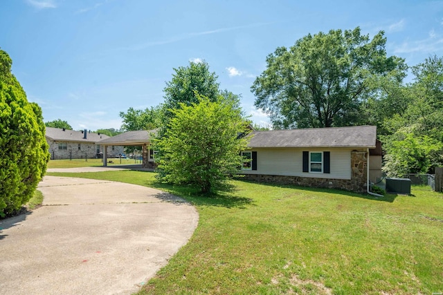 ranch-style house with a front lawn, driveway, stone siding, and a carport
