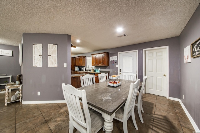 2939 Finch Rd, Bismarck, AR 71929 - dining space featuring a textured ceiling, baseboards, and dark tile patterned flooring