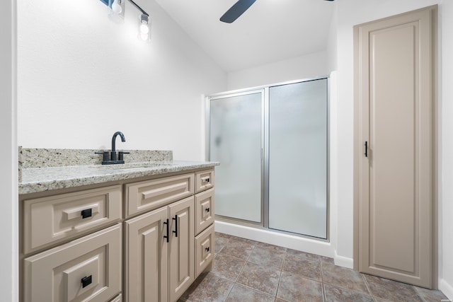 full bathroom featuring ceiling fan, a stall shower, and vanity