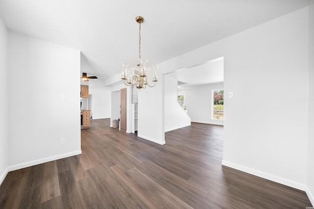 unfurnished dining area with a notable chandelier, dark wood finished floors, and baseboards