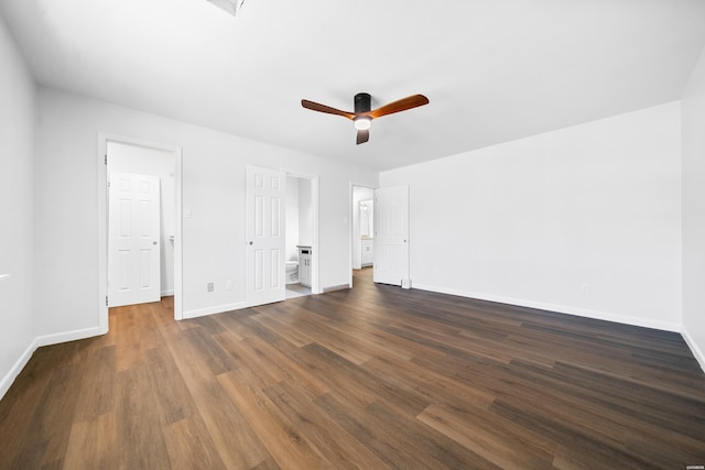 unfurnished bedroom featuring dark wood-style floors, ceiling fan, connected bathroom, and baseboards