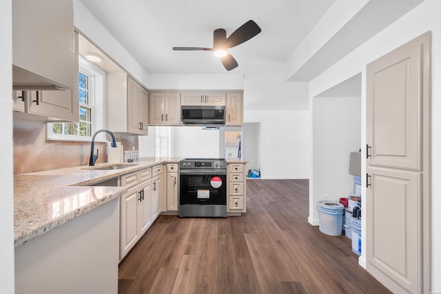 kitchen with ceiling fan, light stone counters, dark wood-style flooring, stainless steel appliances, and a sink