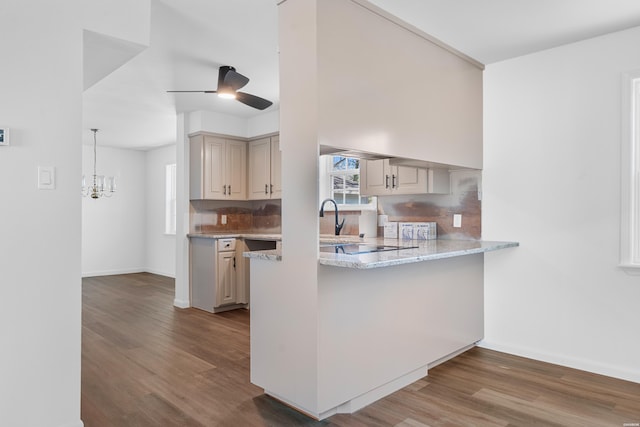 kitchen with tasteful backsplash, cream cabinets, wood finished floors, and pendant lighting