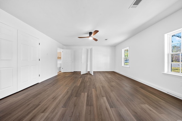 unfurnished bedroom with a ceiling fan, dark wood-style flooring, visible vents, and baseboards