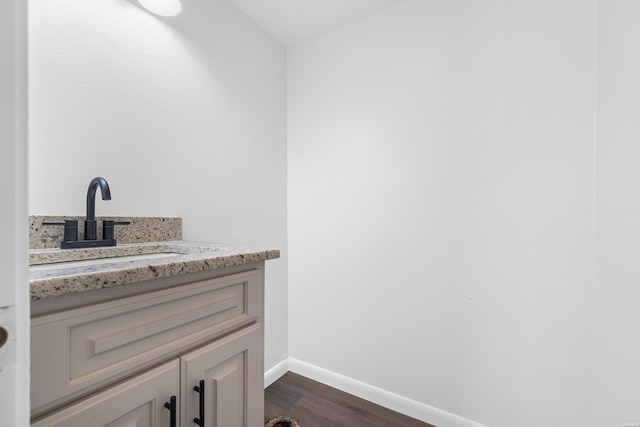 bathroom with vanity, baseboards, and wood finished floors