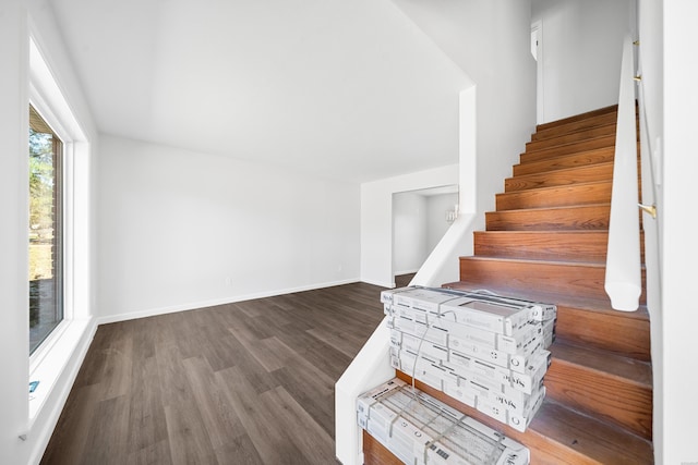 staircase with wood finished floors and baseboards