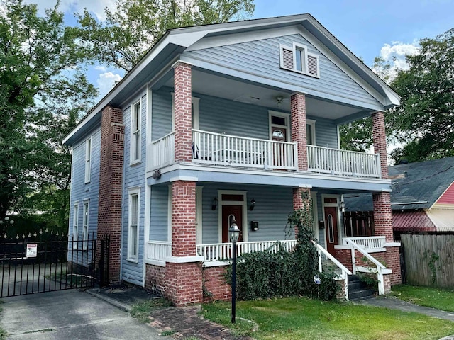 view of front of home with a porch, fence, and a balcony