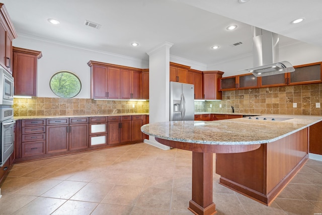 kitchen featuring a breakfast bar, island exhaust hood, appliances with stainless steel finishes, glass insert cabinets, and a peninsula