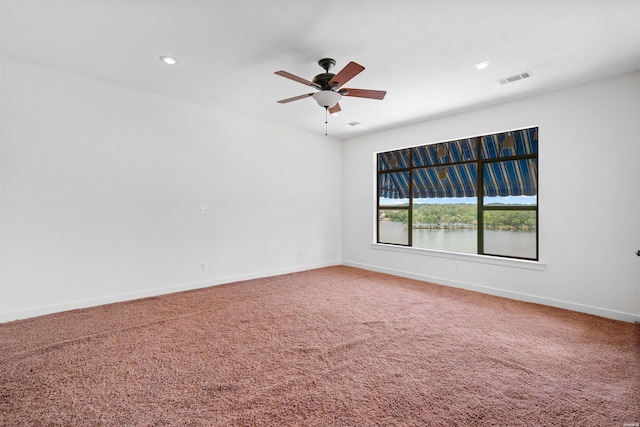 spare room featuring visible vents, baseboards, a water view, carpet, and recessed lighting