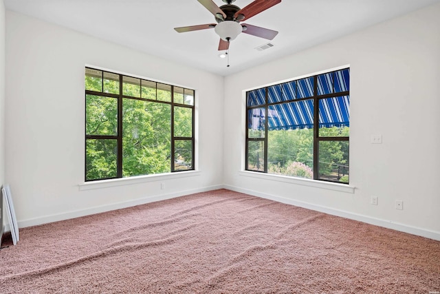 unfurnished room featuring visible vents, carpet, a wealth of natural light, and baseboards