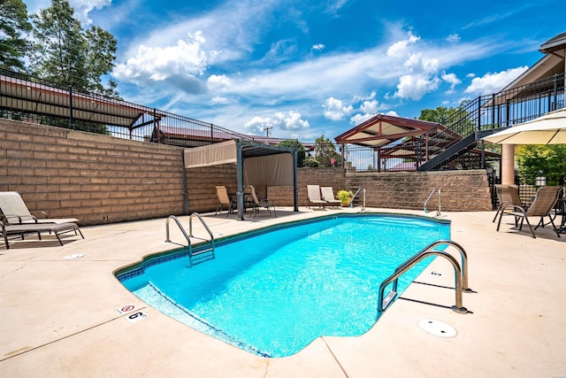 pool featuring a gazebo, a patio area, and fence